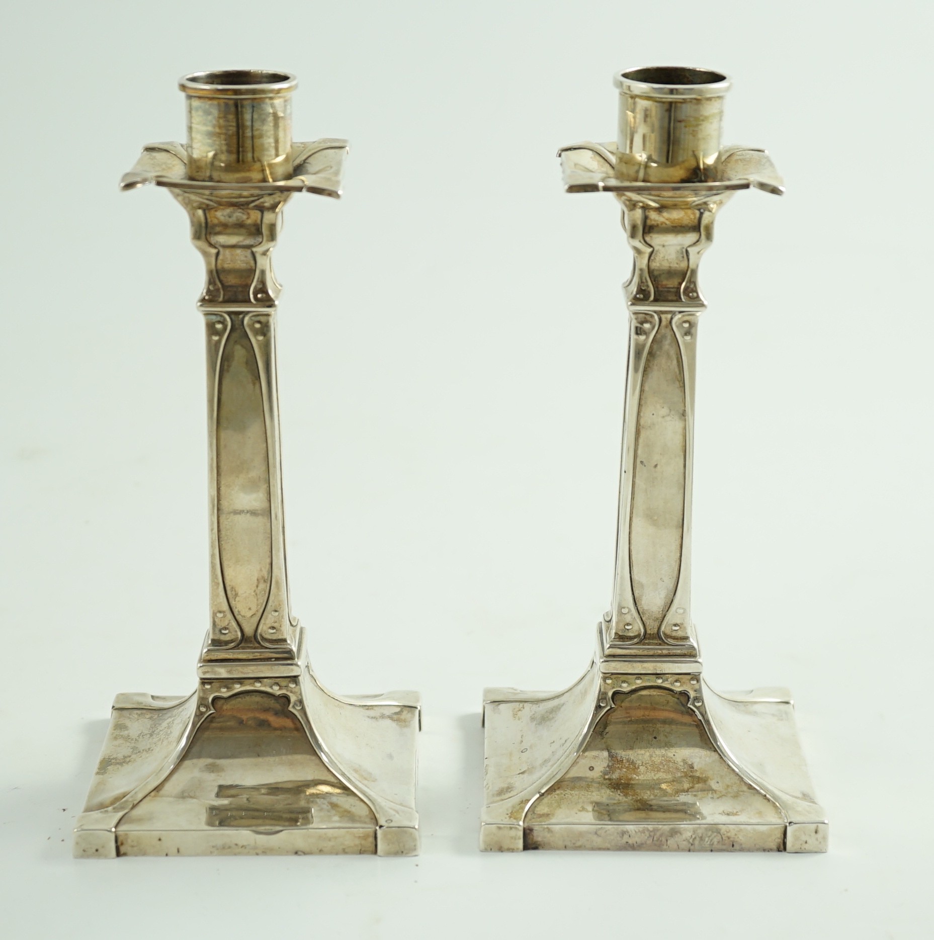 A pair of George V Arts & Crafts silver candlesticks, by William Hutton & Sons
